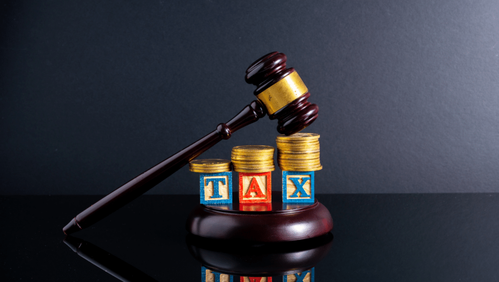 Judge’s gavel resting on stacks of coins and blocks spelling “TAX,” symbolizing estate tax law and financial planning.